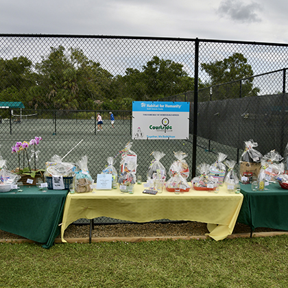 Courtside Tennis Club, Venice, Florida - tables of gift baskets along courtside fence